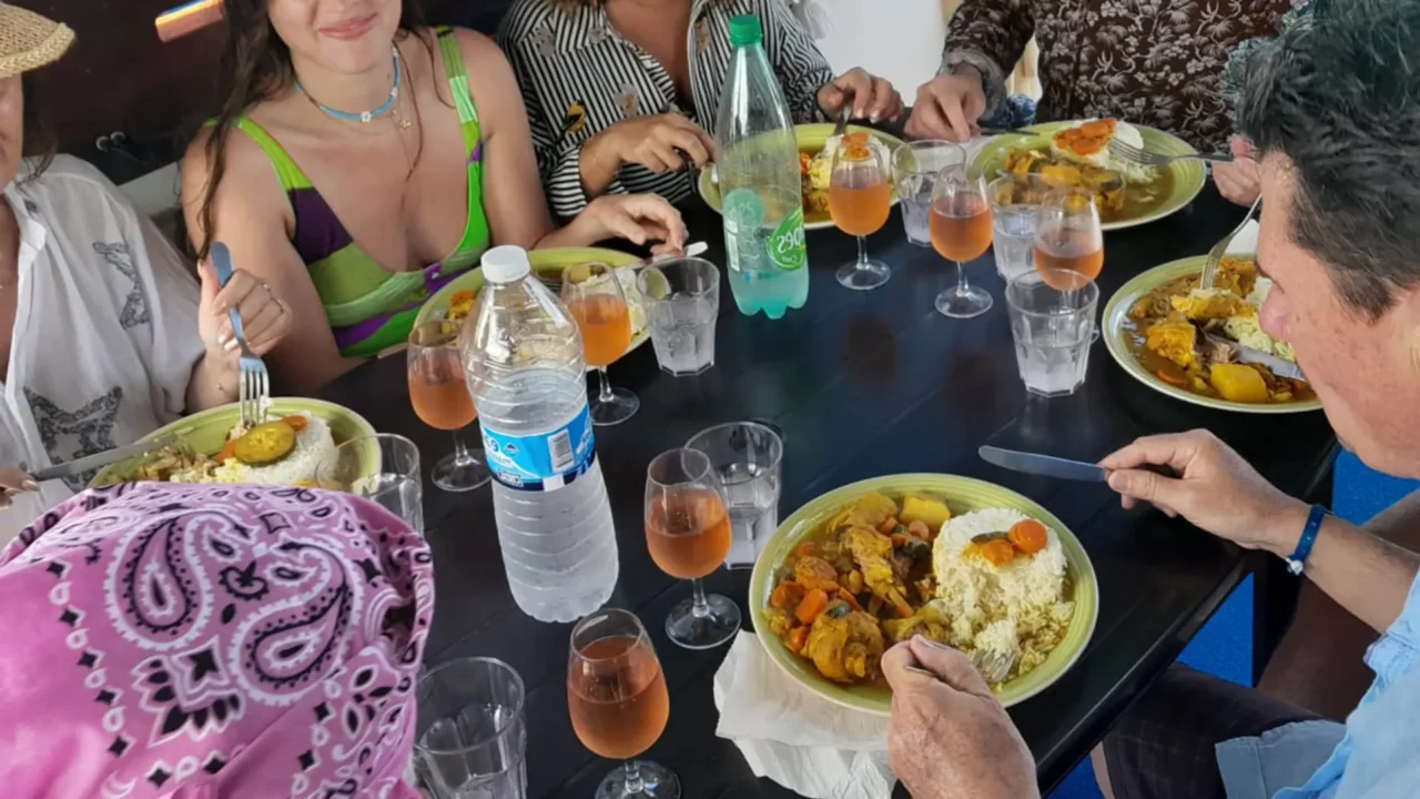 Passagers dégustant un repas créole à bord d’un catamaran à moteurs dans le Grand-Cul-de-Sac-Marin en Guadeloupe.