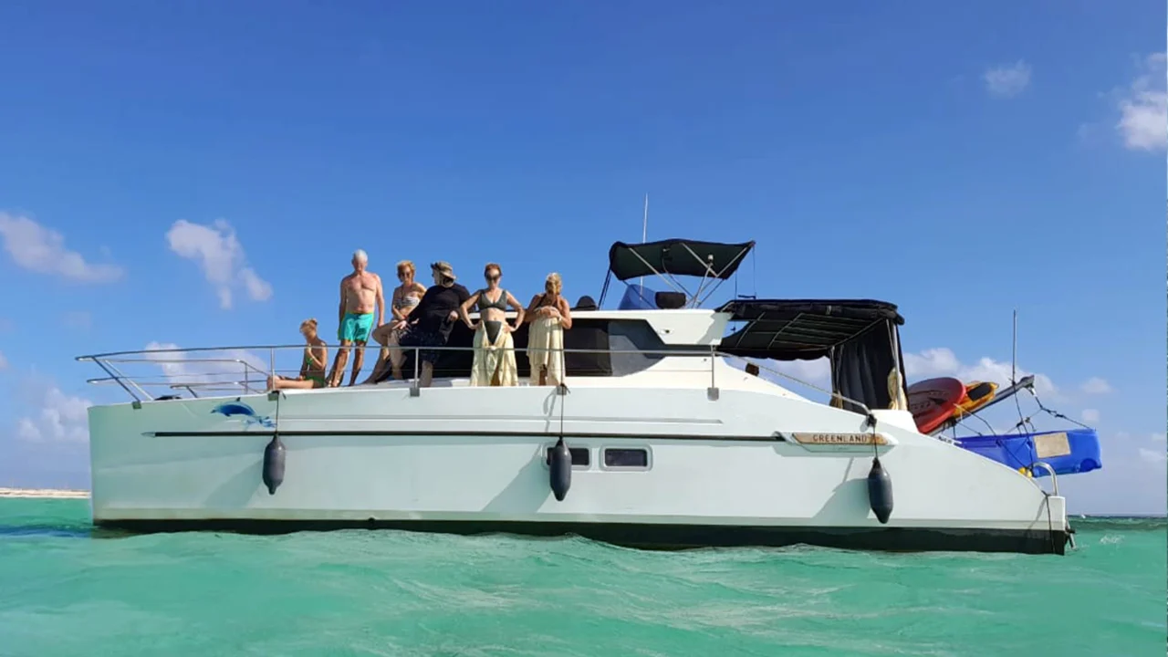 Groupe de passagers à bord d’un catamaran à moteurs sur les eaux turquoise du Grand-Cul-de-Sac-Marin en Guadeloupe.